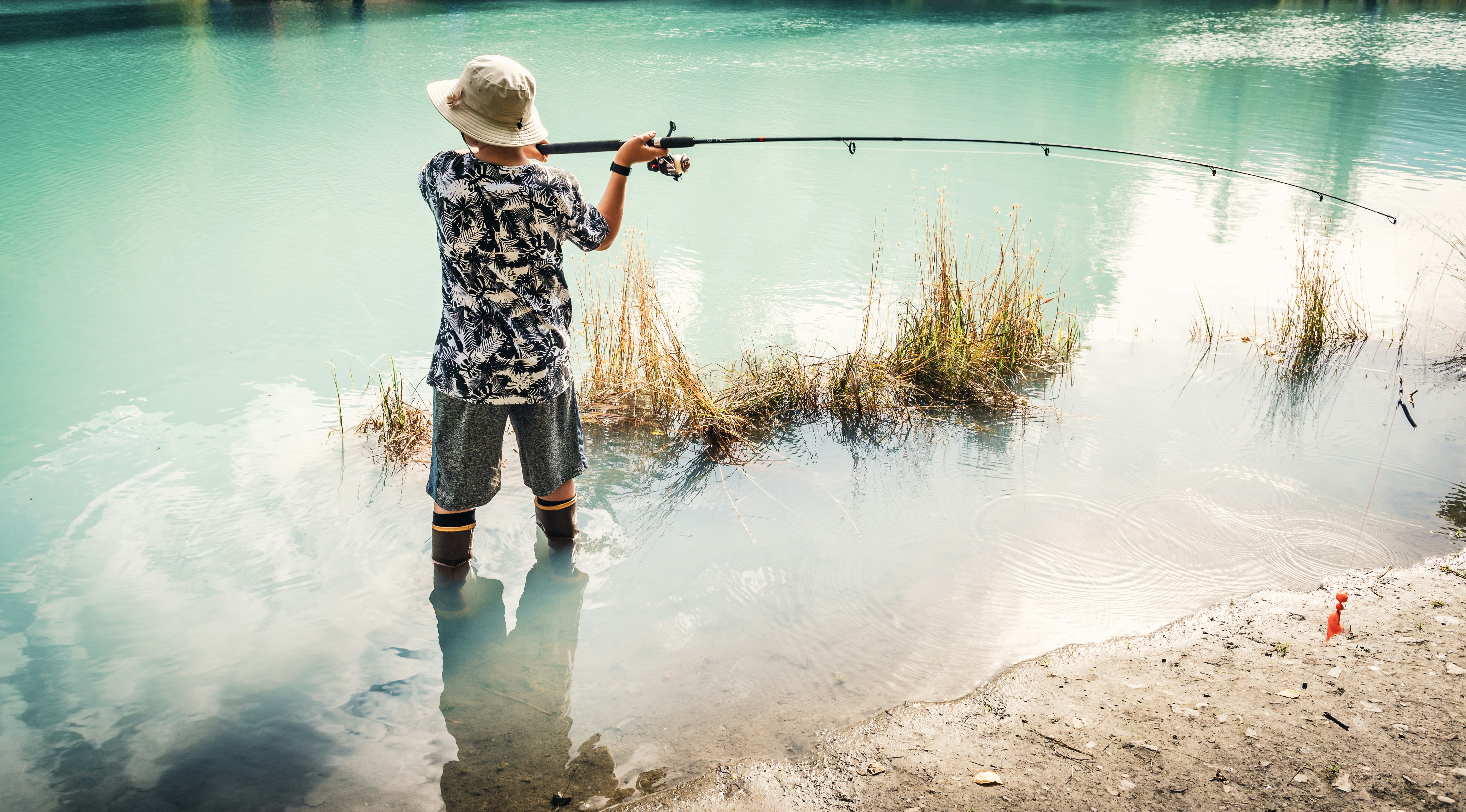 Serene fishing experience by turquoise water, showcasing fishing gear and natures beauty.