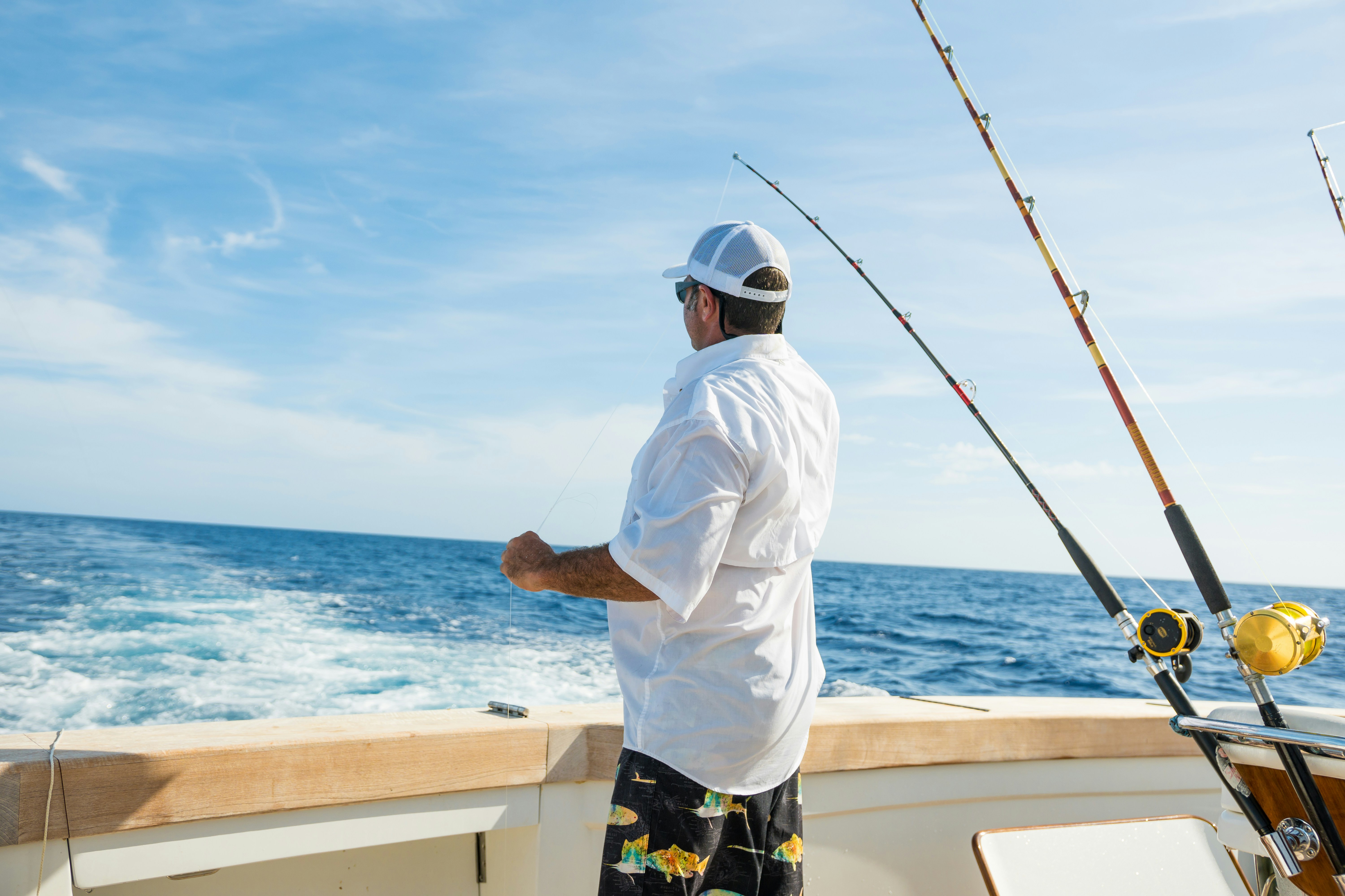 Man on fishing boat enjoying relaxing ocean adventure with gear ready for a catch.