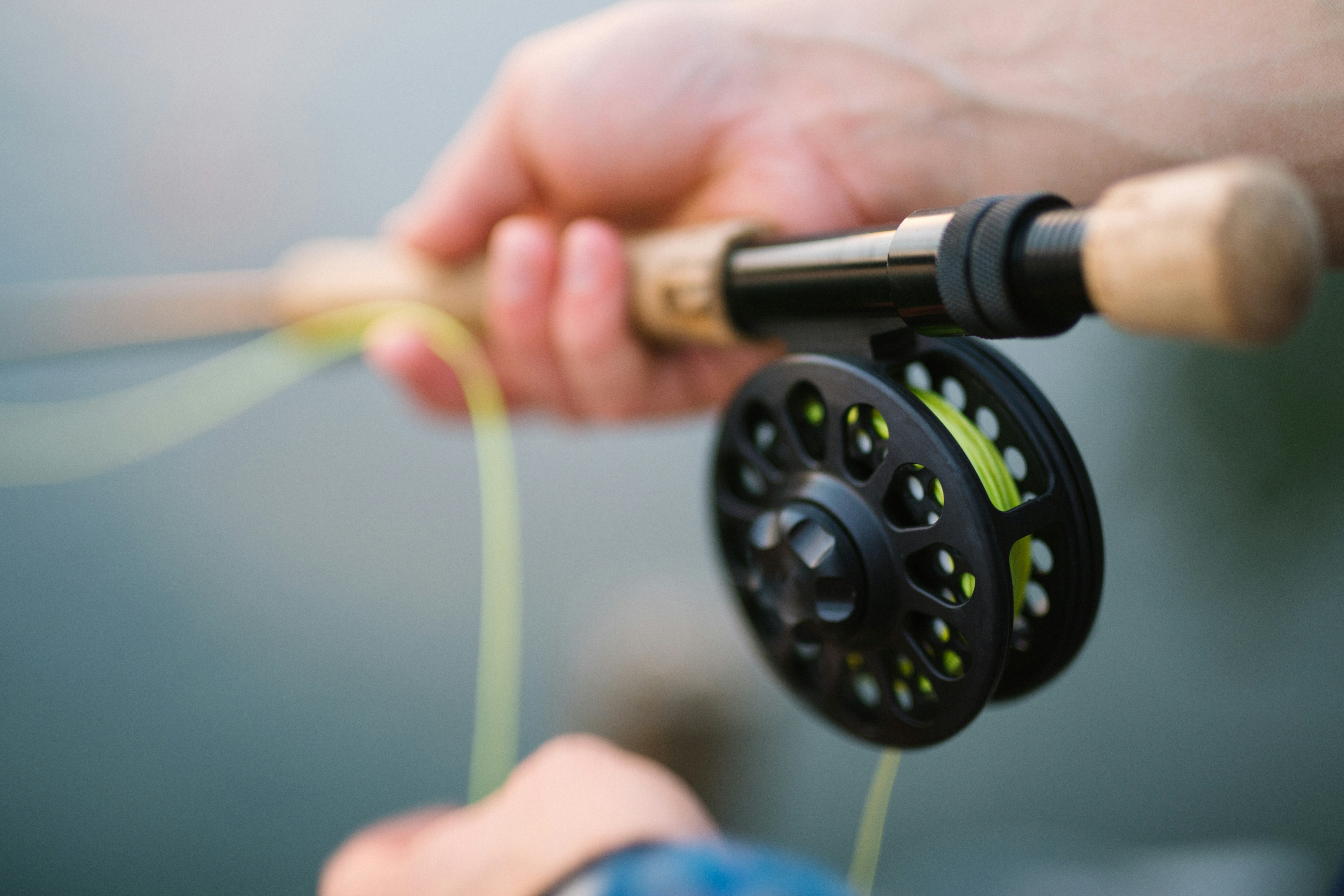 Close-up of premium fishing gear, including a fly rod, reel, and vibrant fishing line.