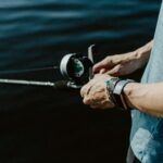 Focused angler holding a fishing rod, showcasing the art of fishing in natures tranquility.