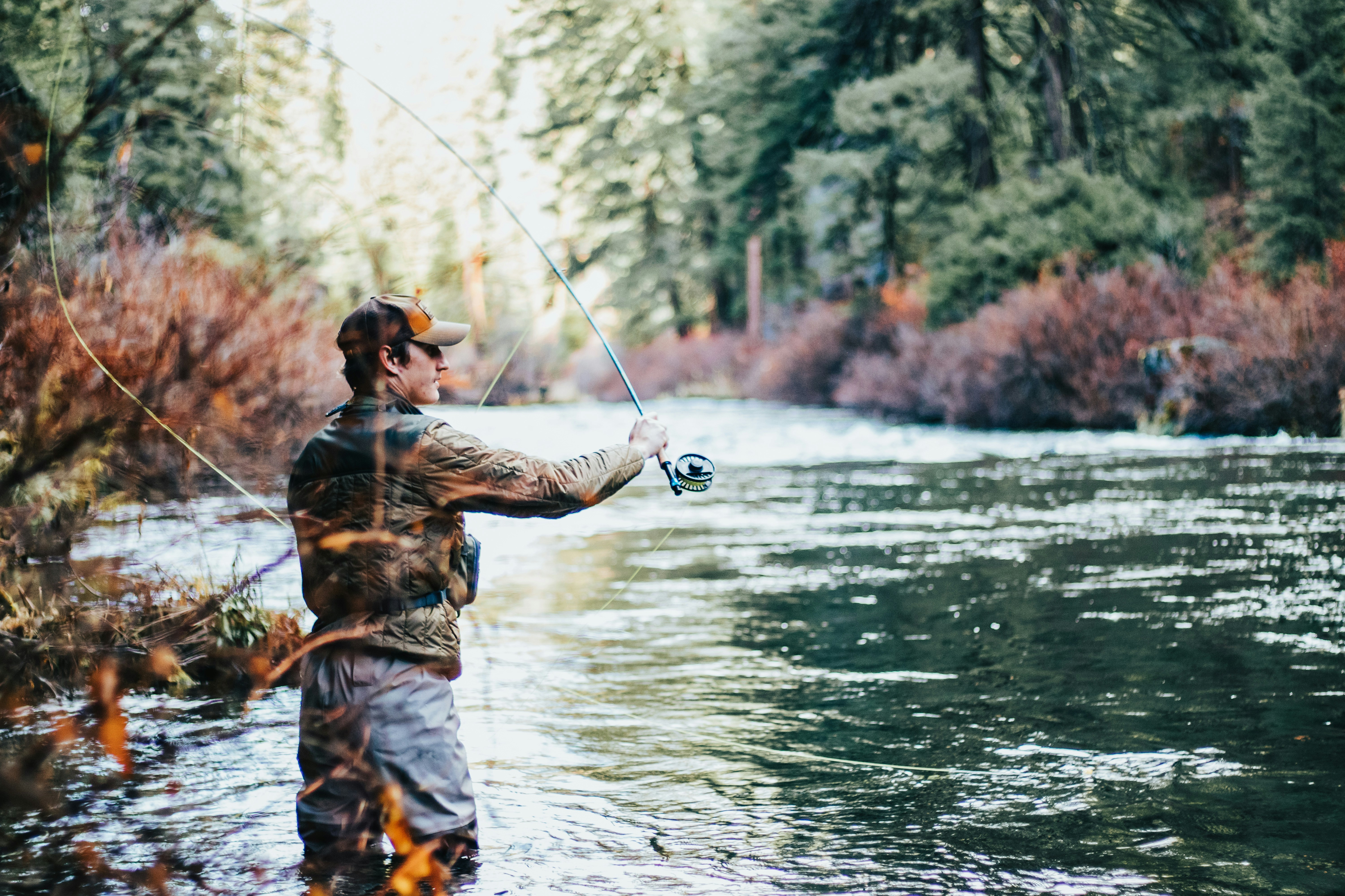 Serene river fishing scene with a fisherman casting a line in natures tranquility.