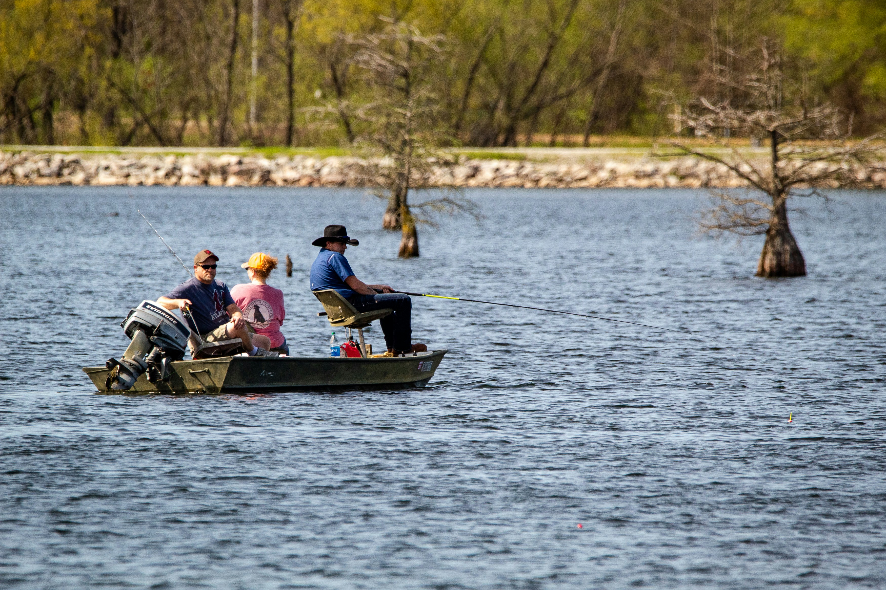 Fishing trip on a spring lake with a serene boat, anglers, and vibrant nature scenery.