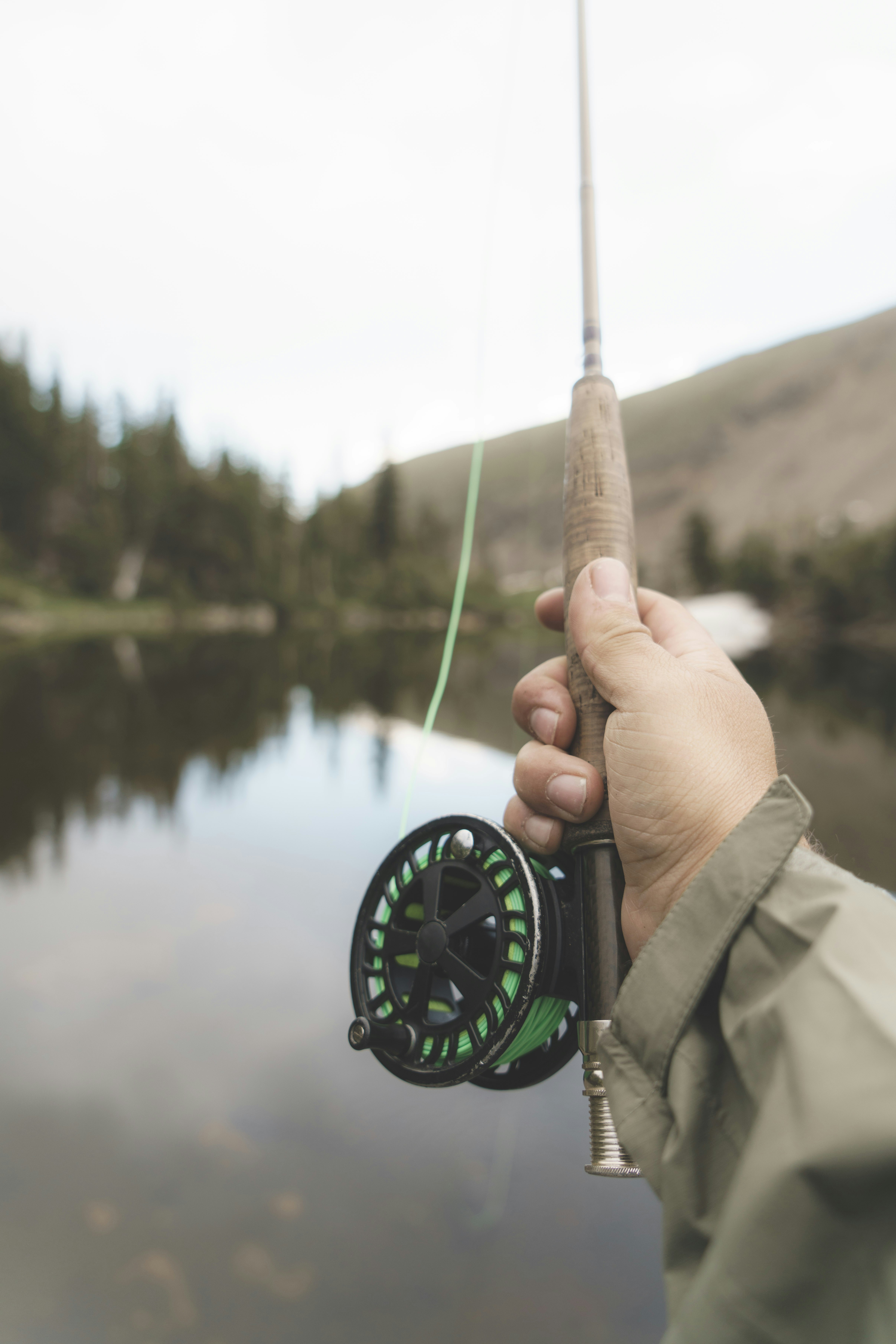 Peaceful fly fishing scene by a tranquil lake, showcasing fishing gear and natures beauty.