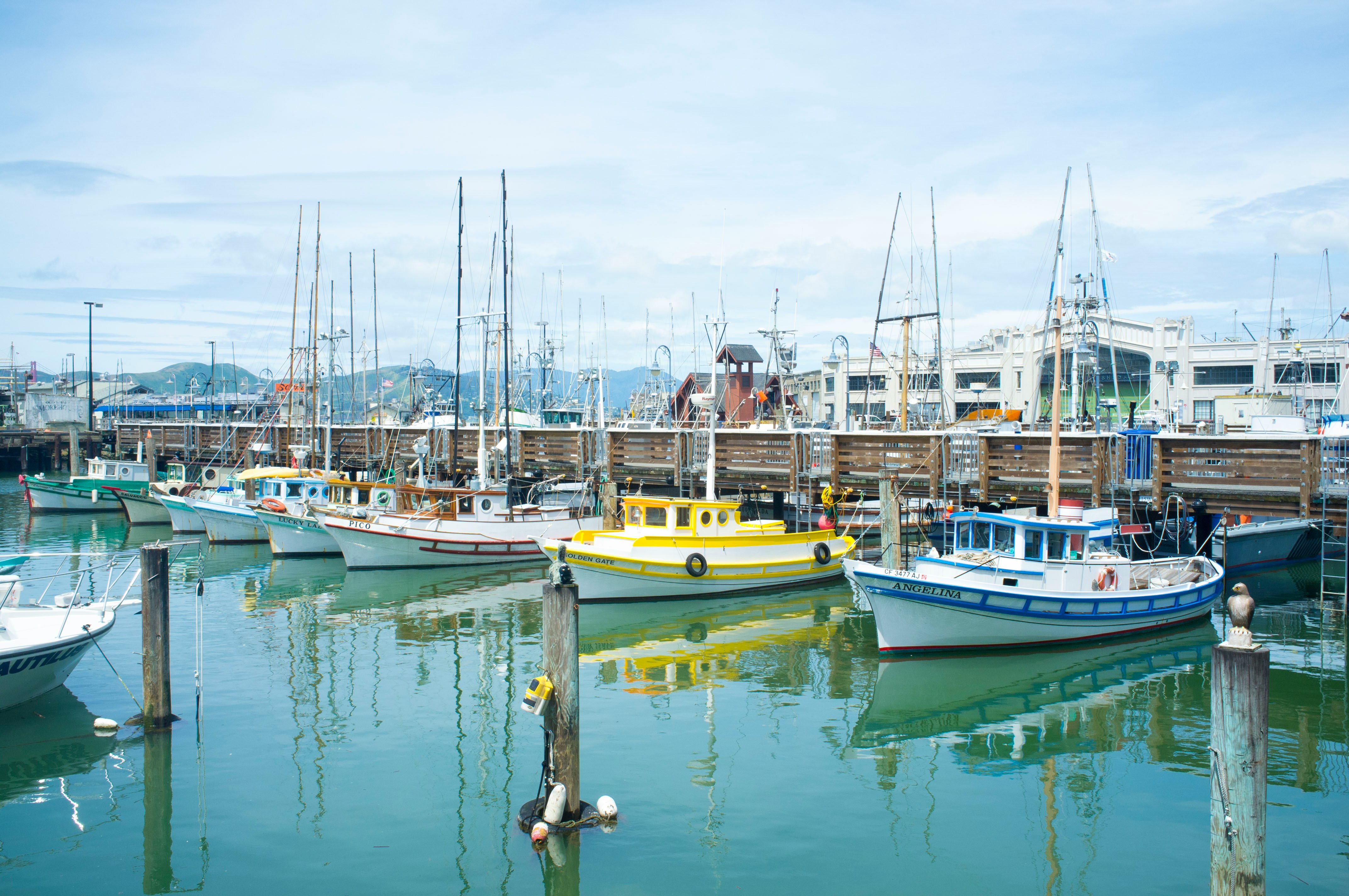 Vibrant harbor scene with colorful boats, fishing gear, and serene turquoise water.