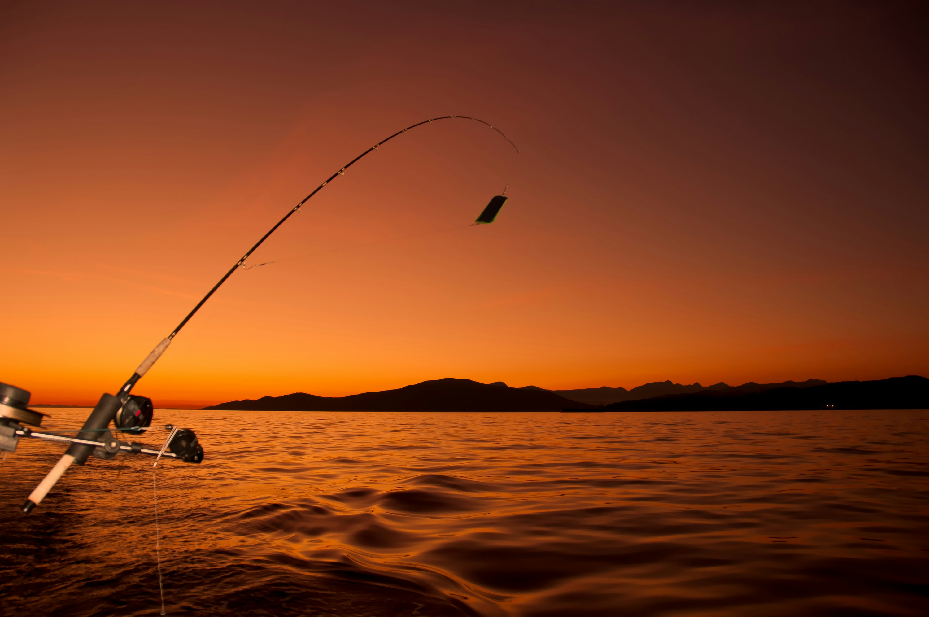 Serene sunset fishing scene with modern gear, perfect for outdoor enthusiasts at the lake.